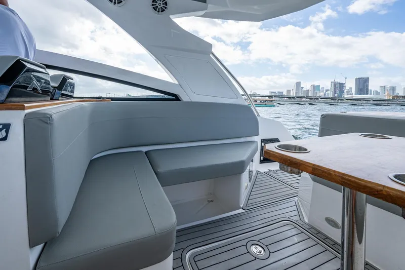 Xuru Yacht Photos Pics Luxurious 2023 NX 340 yacht interior with city skyline view, featuring sleek seating and wooden table.