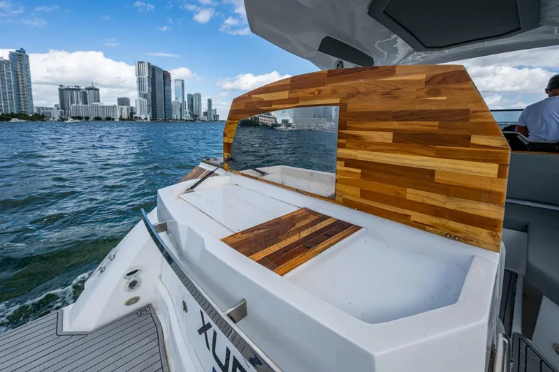 Xuru Yacht Photos Pics Luxury NX 340 yacht with wooden deck, cruising near city skyline, 2023 model.