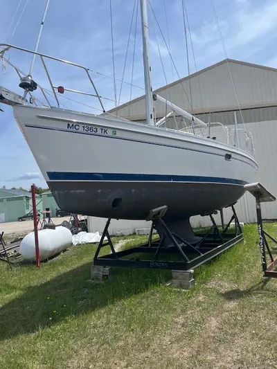 Rita Gale Yacht Photos Pics Catalina 355 sailboat from 2012 on a stand, displayed outdoors near a building.
