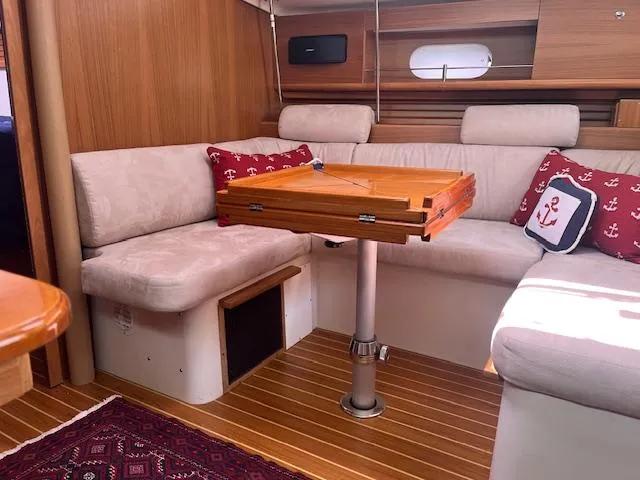 Rita Gale Yacht Photos Pics Cozy interior of 2012 Catalina 355 sailboat with wooden table and cushioned seating.