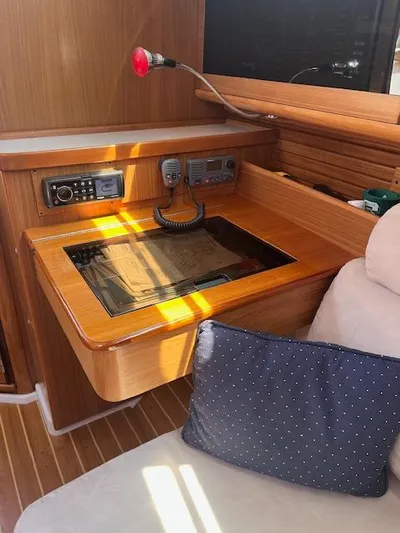 Rita Gale Yacht Photos Pics Navigation station in a 2012 Catalina 355 sailboat with radio equipment and wooden finish.