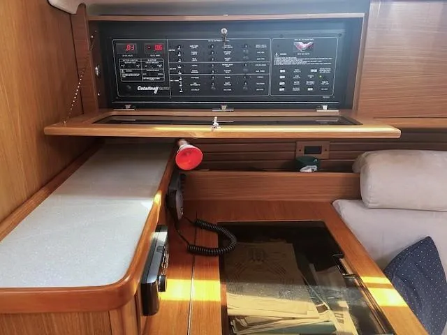 Rita Gale Yacht Photos Pics Control panel inside a 2012 Catalina 355 sailboat cabin, featuring wood finish and navigation equipment.
