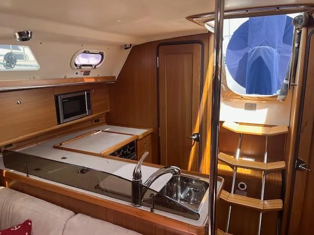 Rita Gale Yacht Photos Pics Interior of 2012 Catalina 355 sailboat with modern kitchen and wooden finishes.