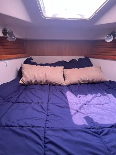 Rita Gale Yacht Photos Pics Cozy cabin interior of 2012 Catalina 355 sailboat with blue bedding and pillows.