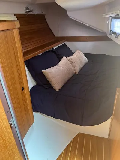Rita Gale Yacht Photos Pics Cozy cabin interior of 2012 Catalina 355 sailboat with bed and wooden accents.