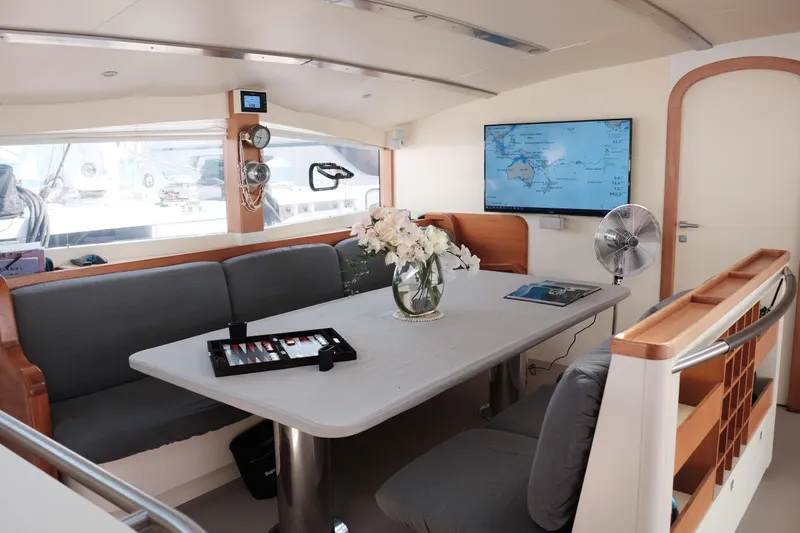 Vitalia II Yacht Photos Pics Interior of 2003 Multiplast High Performance Catamaran with table, seating, and navigation screen.