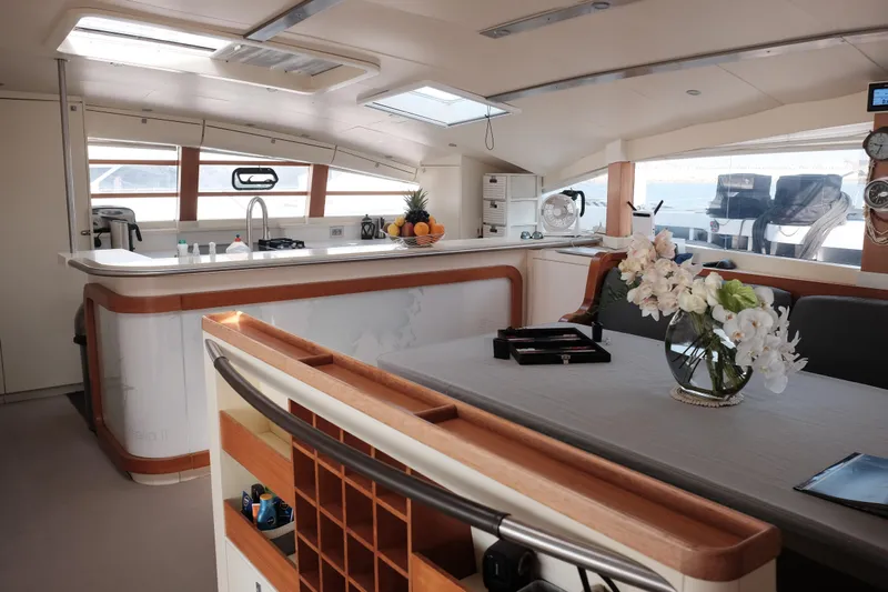 Vitalia II Yacht Photos Pics Luxurious interior of a 2003 Multiplast High Performance Catamaran with modern kitchen and dining area.