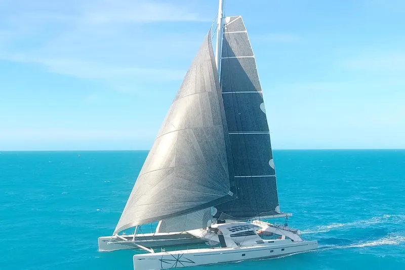 Vitalia II Yacht Photos Pics High-performance Multiplast catamaran sailing on turquoise ocean, 2003 model.