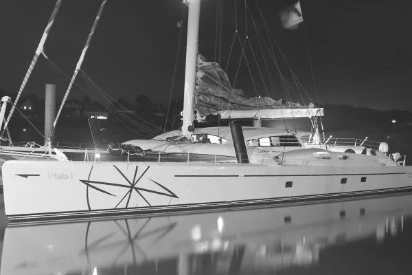 Vitalia II Yacht Photos Pics 2003 Multiplast High Performance Catamaran docked at night, featuring sleek design and sails.