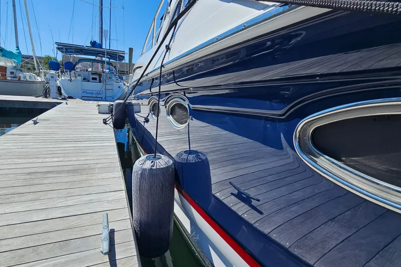  Yacht Photos Pics 2005 Regal Commodore 4260 yacht docked with fenders, reflecting sunlight.