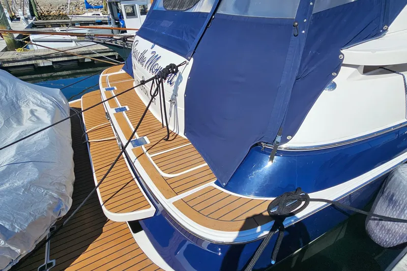  Yacht Photos Pics 2005 Regal Commodore 4260 yacht with blue cover and wooden deck at marina.