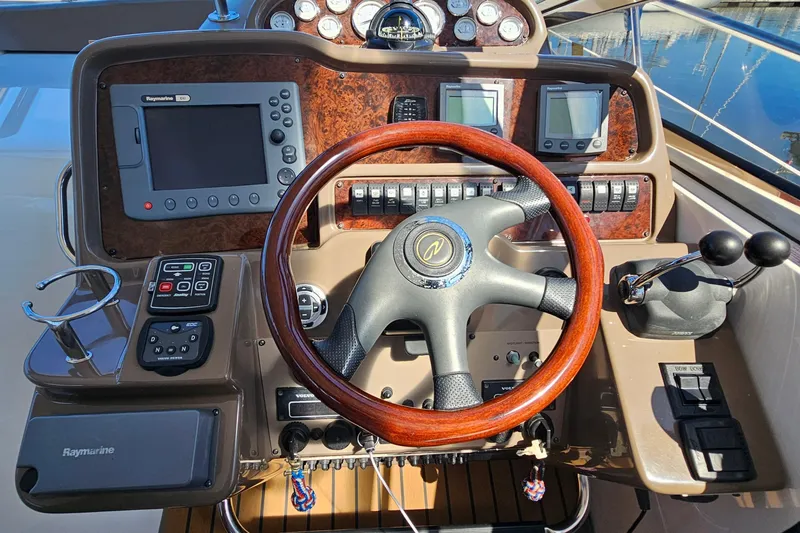  Yacht Photos Pics 2005 Regal Commodore 4260 helm with wood steering wheel and navigation controls.