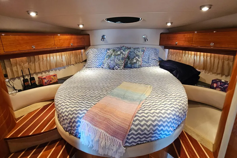  Yacht Photos Pics Luxurious 2005 Regal Commodore 4260 yacht cabin with cozy bed and elegant wood finishes.