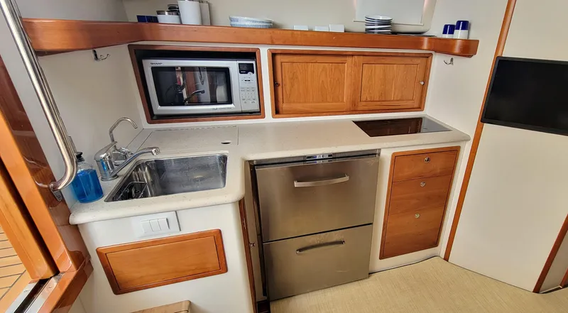 Delilah Yacht Photos Pics Compact kitchen in 2011 MJM 40z Downeast boat with sink, microwave, and storage.