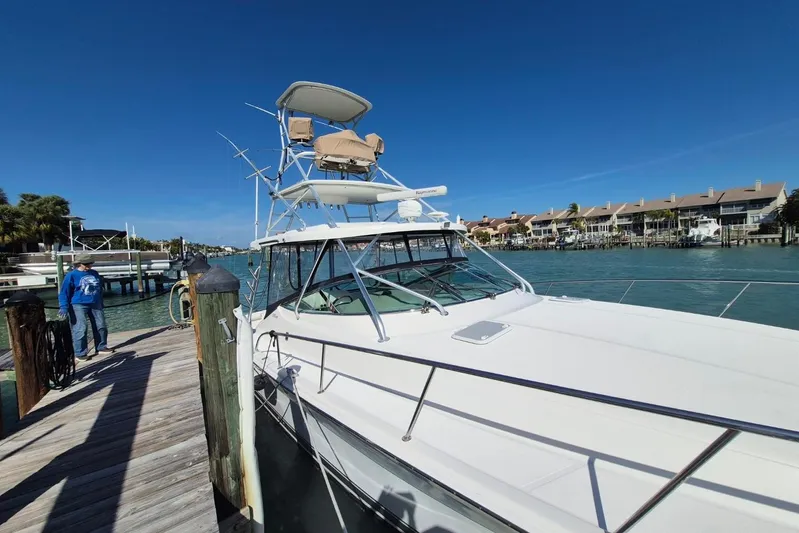  Yacht Photos Pics 2004 Riviera 4000 Offshore yacht docked by waterfront homes under clear blue sky.