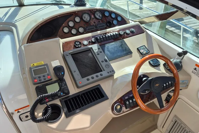  Yacht Photos Pics Control panel of a 2004 Riviera 4000 Offshore boat with wooden steering wheel.