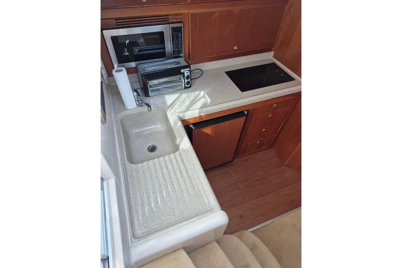  Yacht Photos Pics 2004 Riviera 4000 Offshore yacht kitchen with sink, microwave, and stove.