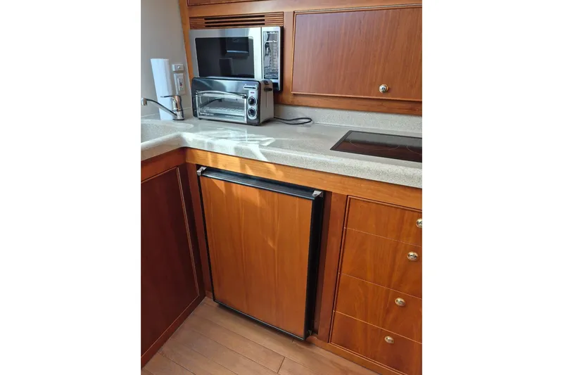  Yacht Photos Pics 2004 Riviera 4000 Offshore yacht kitchen with wooden cabinetry and modern appliances.