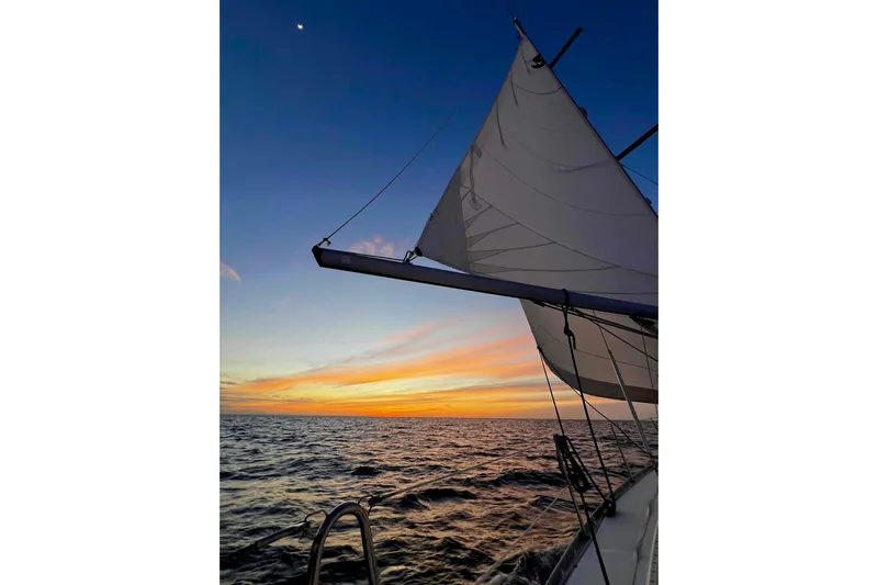 Monlove Yacht Photos Pics Sailing at sunset on a 2007 Beneteau 393, with vibrant sky and calm sea.