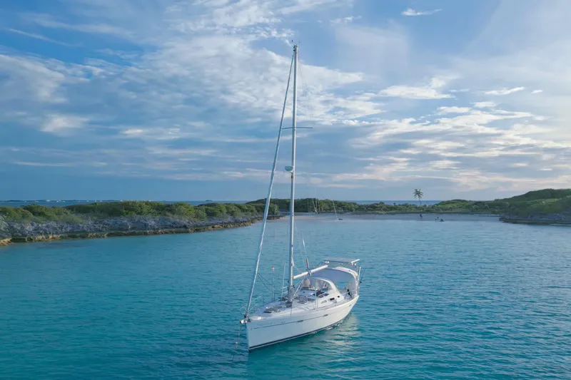 Monlove Yacht Photos Pics 2007 Beneteau 393 sailboat anchored in a serene, turquoise bay under a blue sky.