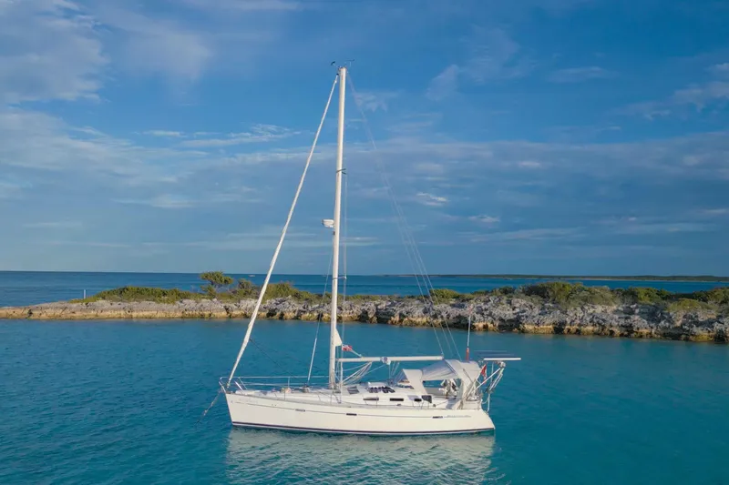 Monlove Yacht Photos Pics Sailboat Beneteau 393 (2007) anchored in clear blue water near rocky shoreline.