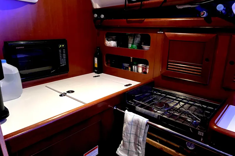 Monlove Yacht Photos Pics Galley kitchen in 2007 Beneteau 393 yacht with microwave, stove, and storage.
