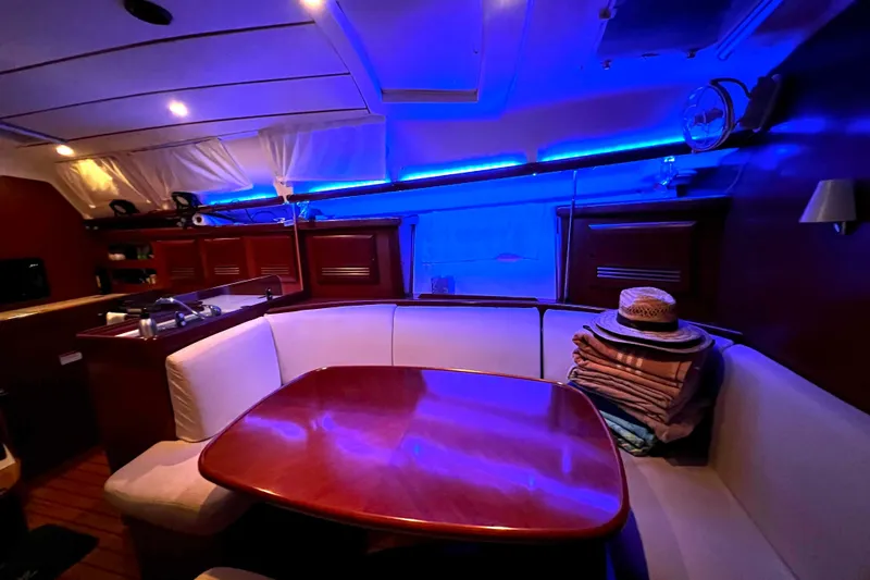 Monlove Yacht Photos Pics Interior of 2007 Beneteau 393 yacht with cozy seating and ambient blue lighting.