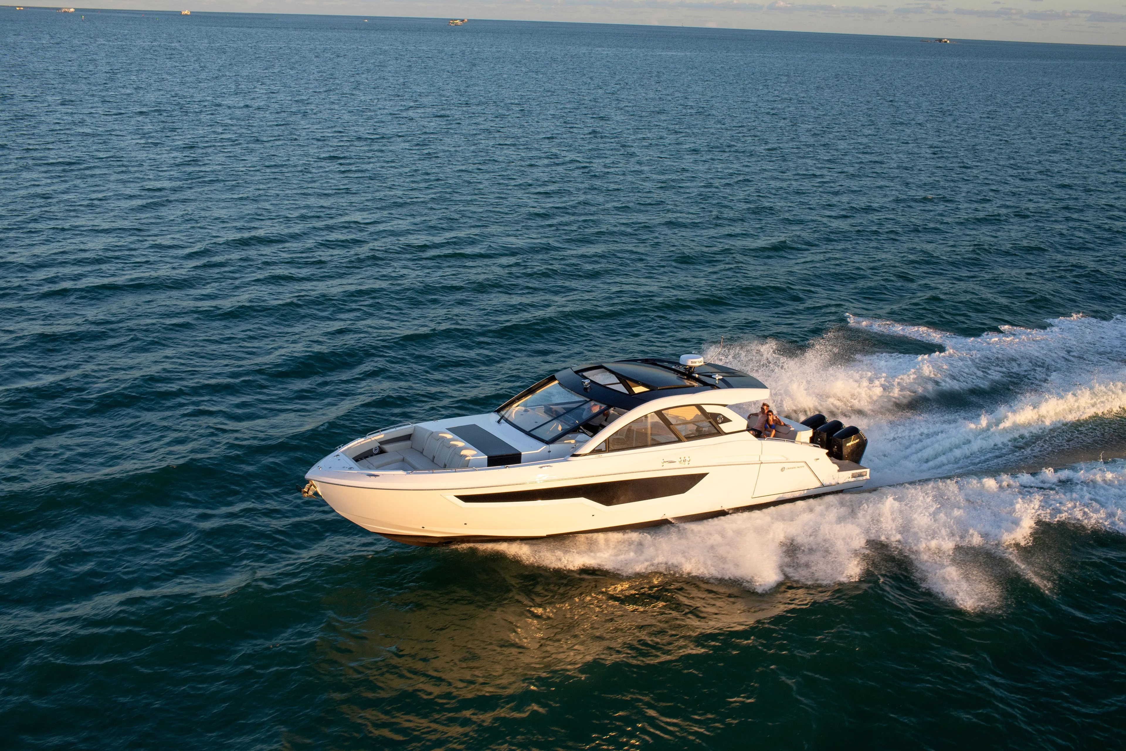  Yacht Photos Pics 2026 Cruisers Yachts 50 GLS speeding on open water at sunset.