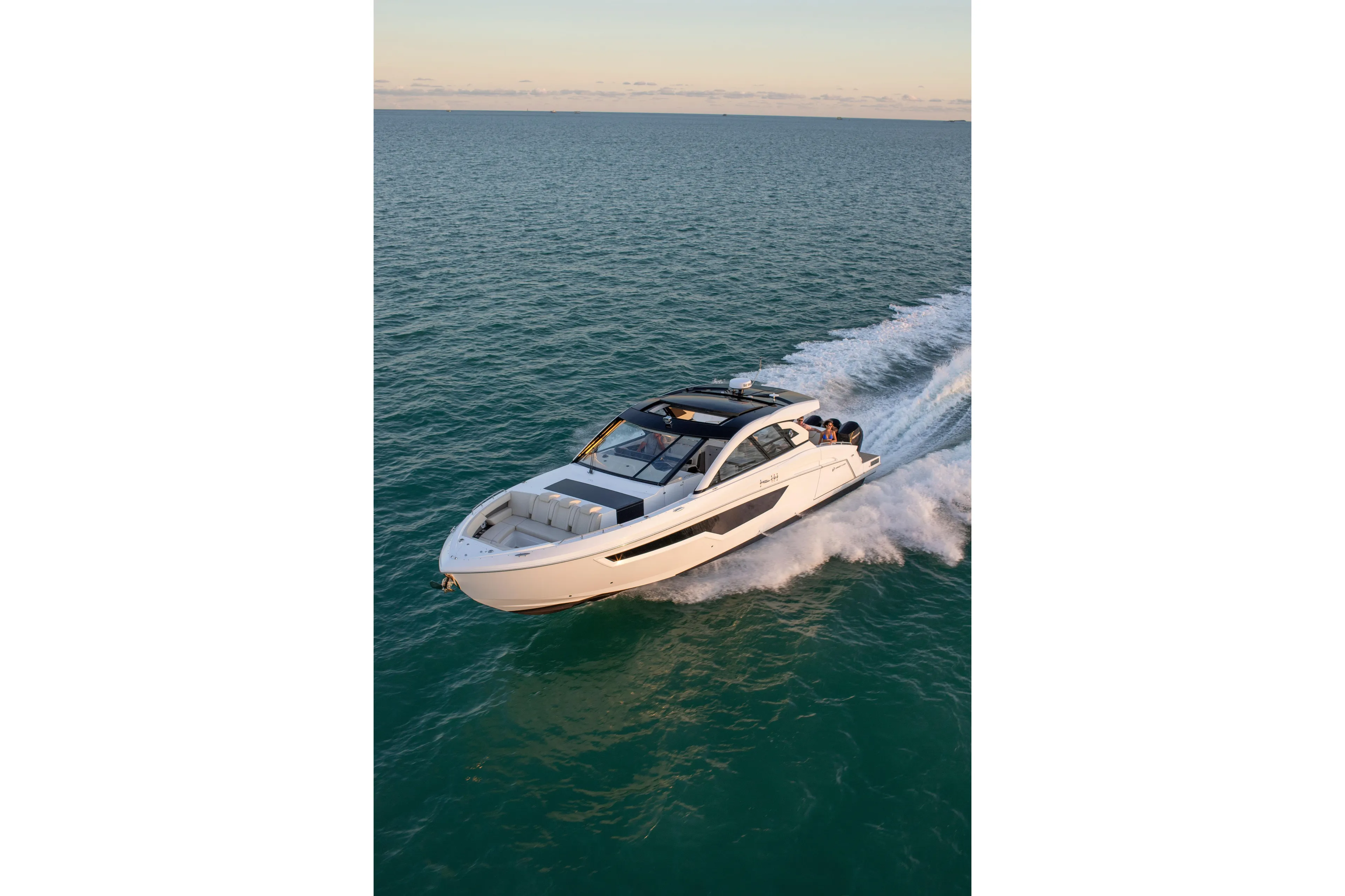  Yacht Photos Pics 2026 Cruisers Yachts 50 GLS speeding on open water at sunset.