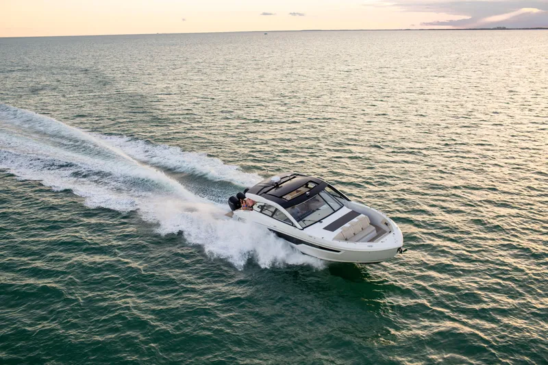  Yacht Photos Pics 2026 Cruisers Yachts 50 GLS speeding on open water at sunset.