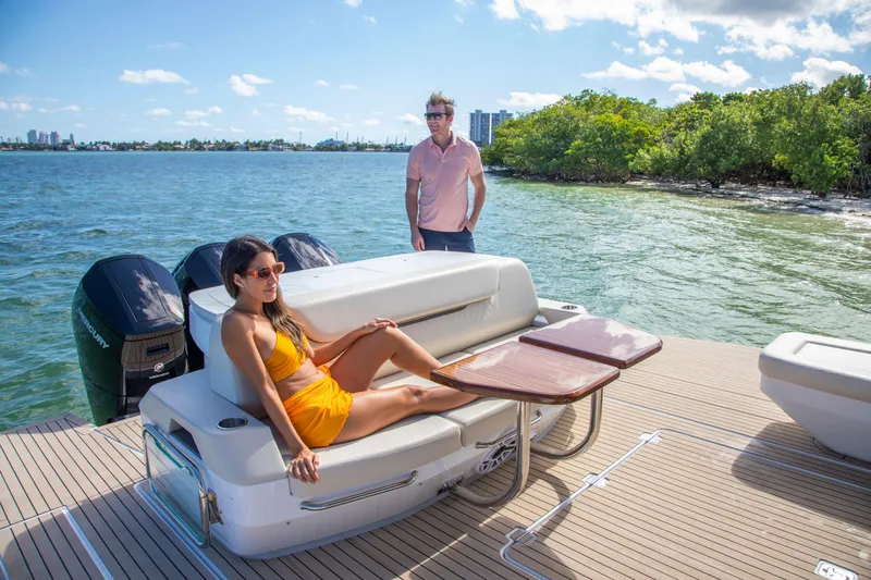  Yacht Photos Pics 2026 Cruisers Yachts 50 GLS with people relaxing on deck, scenic water view.