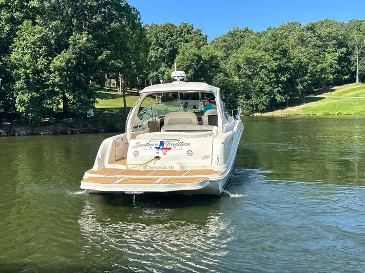  Yacht Photos Pics 2005 Sea Ray 420 Sundancer cruising on a serene lake with lush green surroundings.