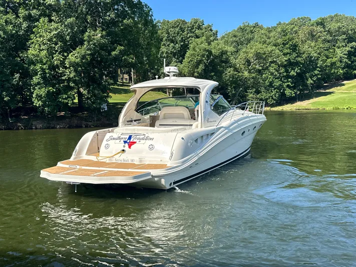  Yacht Photos Pics 2005 Sea Ray 420 Sundancer yacht cruising on a serene lake with lush green trees.