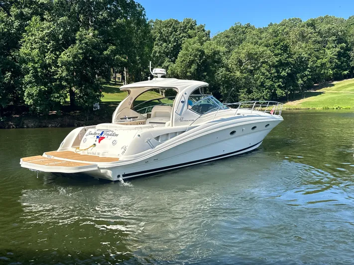  Yacht Photos Pics 2005 Sea Ray 420 Sundancer yacht cruising on a serene lake with lush green surroundings.