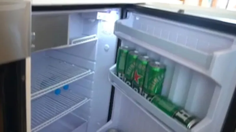 1676 Yacht Photos Pics Open fridge with beverage cans in the door compartment.