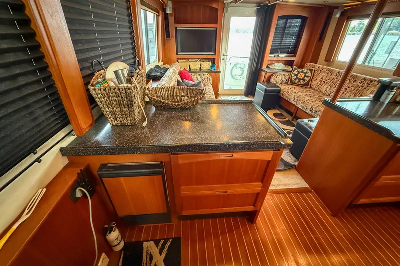 Ring Leader Yacht Photos Pics Interior of 2007 Nordic Tug 54, featuring cozy seating and wooden cabinetry.