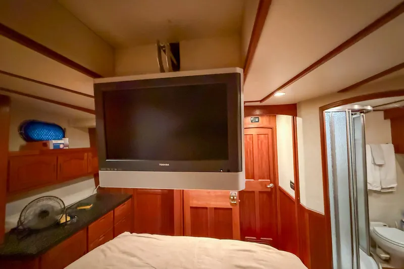 Ring Leader Yacht Photos Pics Interior of 2007 Nordic Tug 54 with TV, wooden cabinetry, and bathroom.