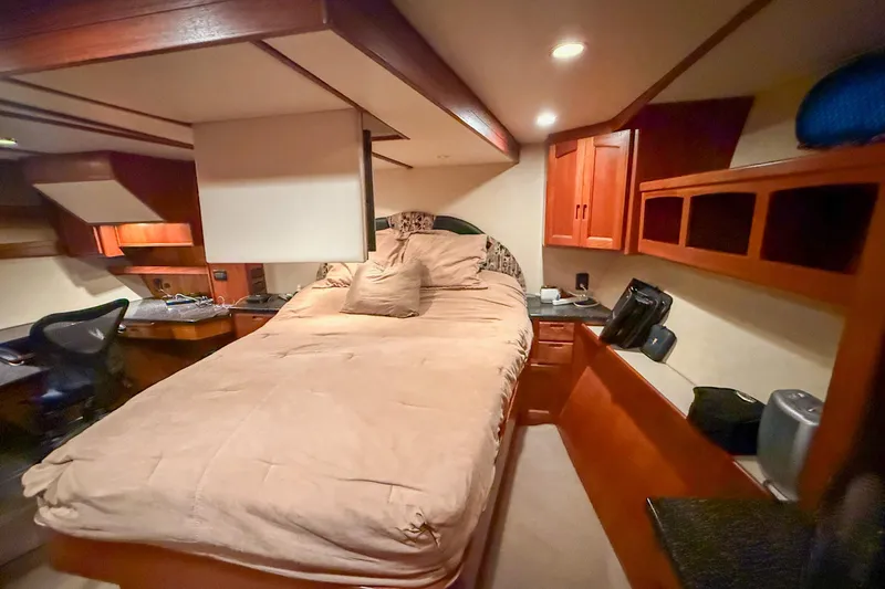 Ring Leader Yacht Photos Pics Cozy bedroom interior of 2007 Nordic Tug 54 with wooden cabinetry and desk.
