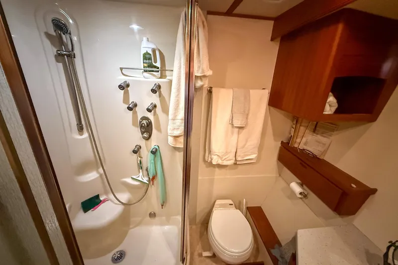 Ring Leader Yacht Photos Pics Compact bathroom in 2007 Nordic Tug 54 with shower, toilet, and wooden cabinetry.