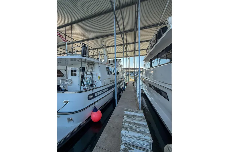 Ring Leader Yacht Photos Pics 2007 Nordic Tug 54 docked in a covered marina, side view with red buoy.