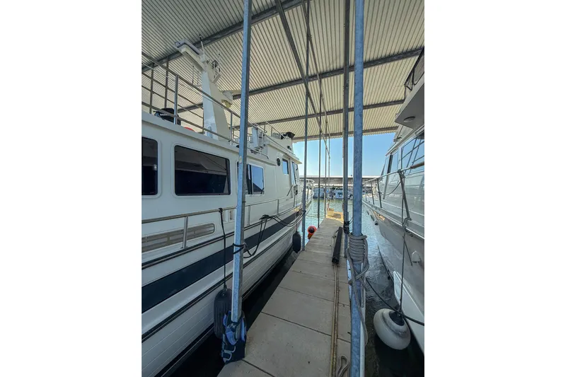 Ring Leader Yacht Photos Pics 2007 Nordic Tug 54 docked in a covered marina, side view.