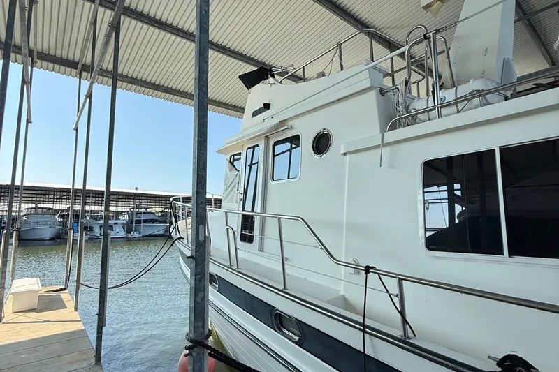 Ring Leader Yacht Photos Pics 2007 Nordic Tug 54 docked in a marina under a covered shelter.