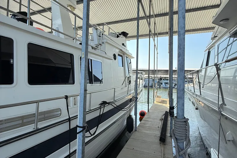 Ring Leader Yacht Photos Pics 2007 Nordic Tug 54 docked in a marina, sheltered under a metal roof.