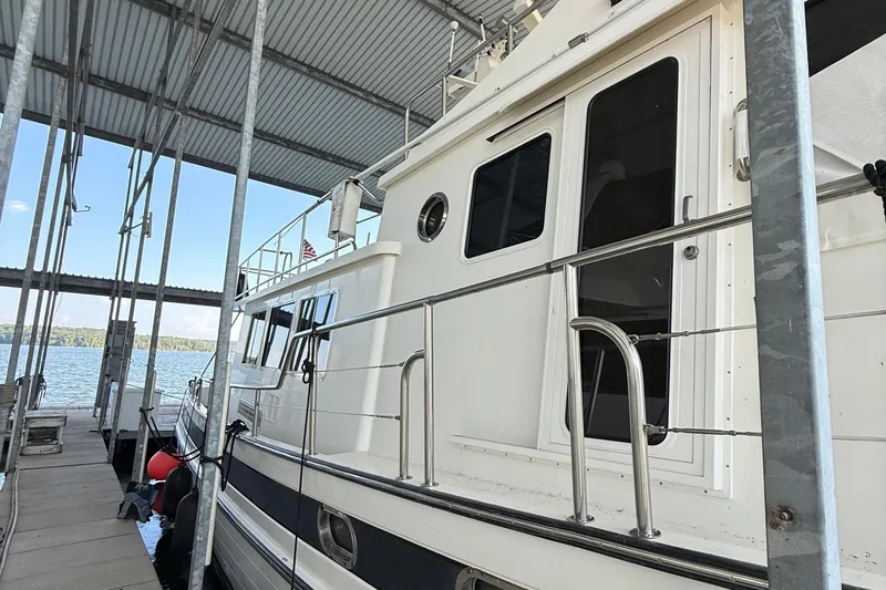 Ring Leader Yacht Photos Pics 2007 Nordic Tug 54 docked under a covered marina with scenic water view.