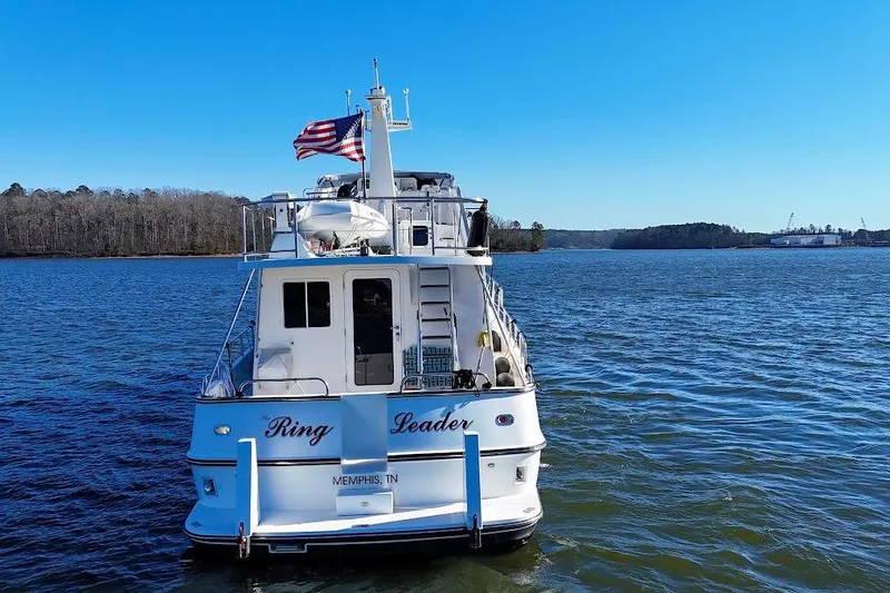 Ring Leader Yacht Photos Pics Nordic Tug 54, 2007 model, cruising on a serene lake under a clear blue sky.
