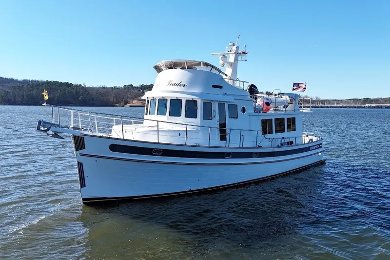 Ring Leader Yacht Photos Pics 2007 Nordic Tug 54 yacht cruising on a calm lake under a clear blue sky.