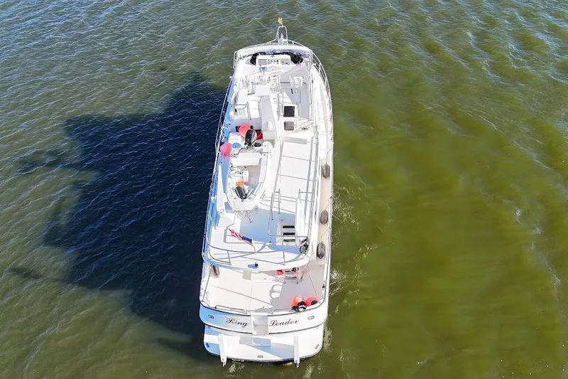 Ring Leader Yacht Photos Pics Nordic Tug 54 (2007) cruising on calm green waters, aerial view.