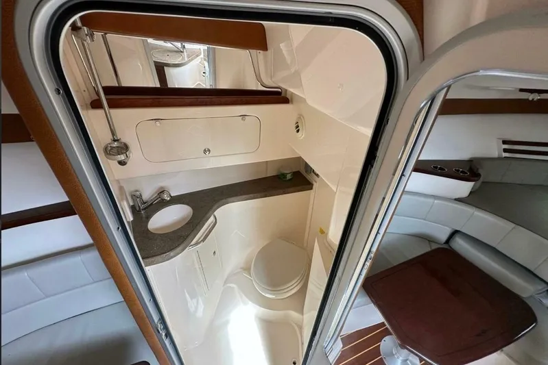  Yacht Photos Pics 2014 Grady-White Express 330 boat interior with compact bathroom and seating area.