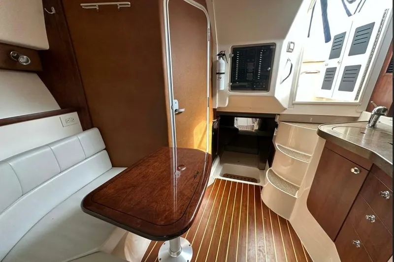  Yacht Photos Pics 2014 Grady-White Express 330 cabin interior with wood flooring and seating area.