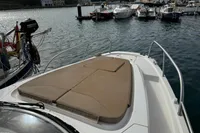 2022 Nimbus W9 boat with sunpad, docked in a scenic marina.
